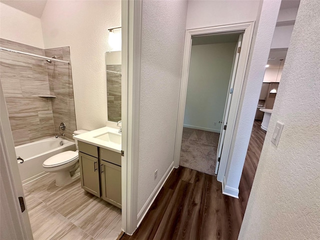 full bathroom with vanity, toilet, tiled shower / bath combo, and hardwood / wood-style floors