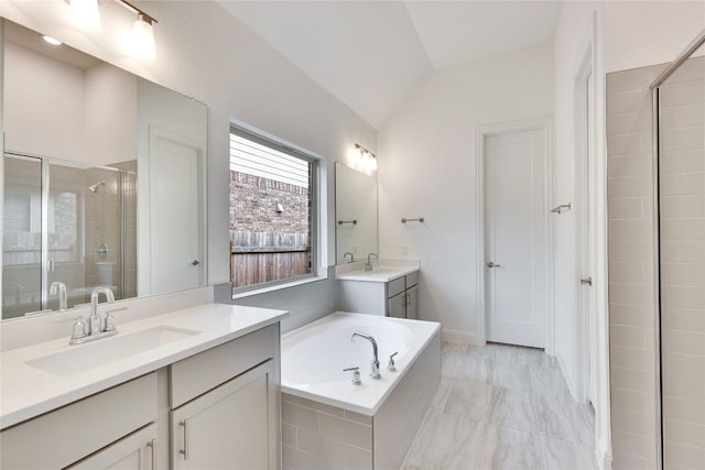 bathroom with a garden tub, vaulted ceiling, a sink, and a shower stall