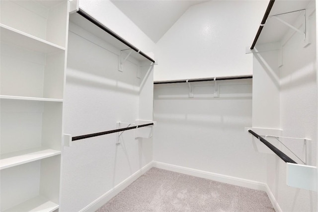 spacious closet featuring lofted ceiling and light carpet