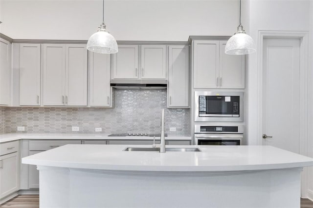 kitchen featuring light countertops, appliances with stainless steel finishes, gray cabinets, and under cabinet range hood