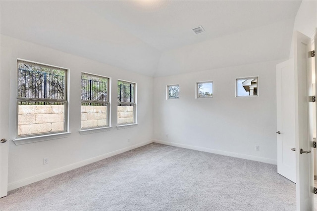 unfurnished room featuring lofted ceiling, carpet, visible vents, and baseboards