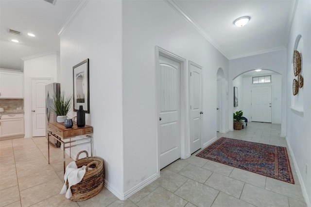 entrance foyer featuring ornamental molding and light tile patterned floors