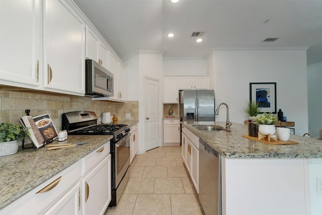 kitchen featuring sink, appliances with stainless steel finishes, a kitchen island with sink, and white cabinetry