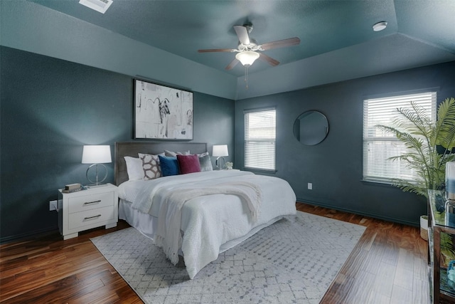 bedroom featuring dark hardwood / wood-style flooring, lofted ceiling, and ceiling fan