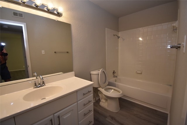 full bathroom with toilet, vanity, wood-type flooring, and washtub / shower combination