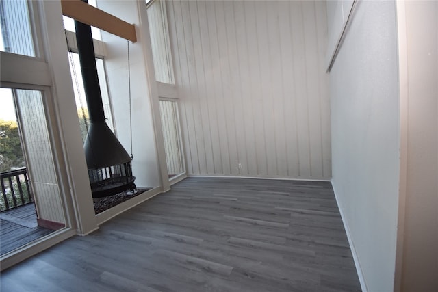 interior space featuring a towering ceiling, dark hardwood / wood-style flooring, and wooden walls