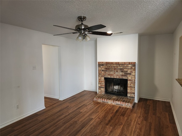 unfurnished living room with a textured ceiling, a fireplace, dark hardwood / wood-style floors, and ceiling fan