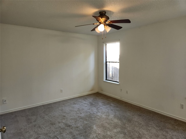 unfurnished room with a textured ceiling, dark carpet, and ceiling fan