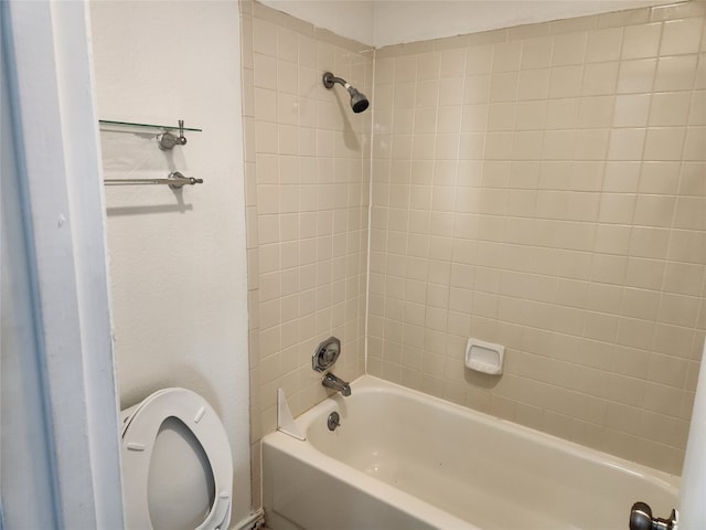 bathroom with tiled shower / bath combo and toilet