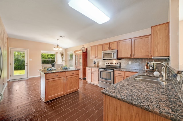 kitchen featuring hanging light fixtures, a kitchen island, an inviting chandelier, sink, and stainless steel appliances