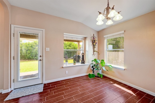 doorway featuring an inviting chandelier and lofted ceiling