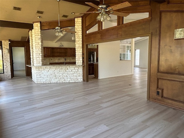 empty room featuring ceiling fan, high vaulted ceiling, and light wood-type flooring