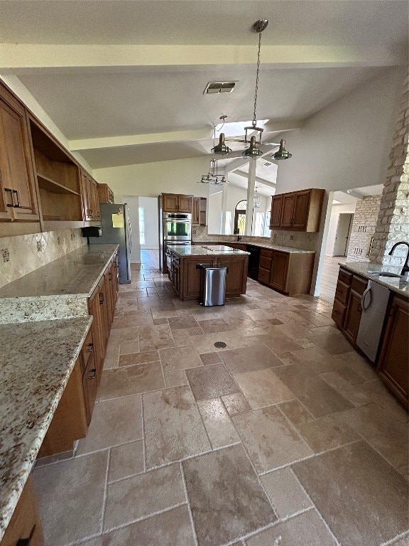 kitchen featuring a healthy amount of sunlight, tasteful backsplash, lofted ceiling, and hanging light fixtures