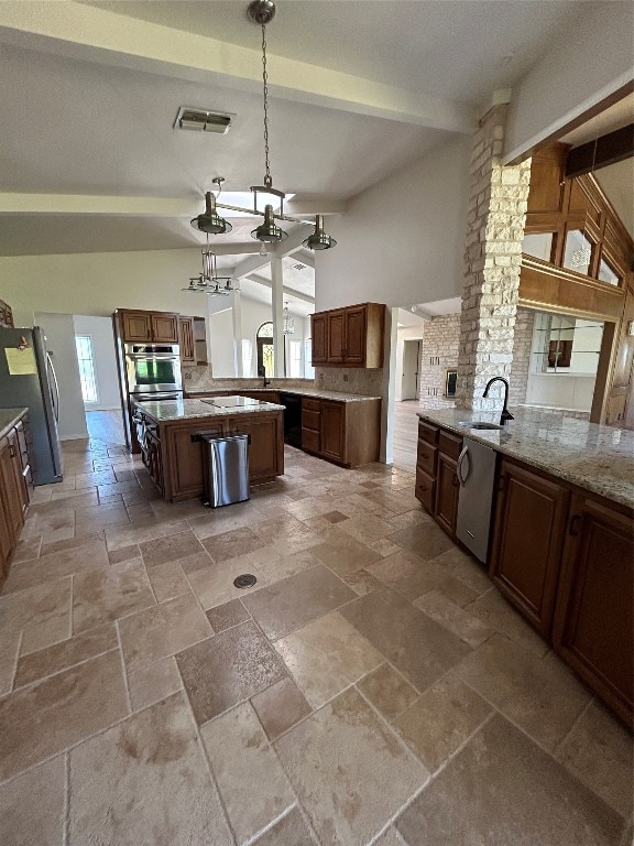 kitchen with stainless steel appliances, beamed ceiling, a wealth of natural light, and pendant lighting