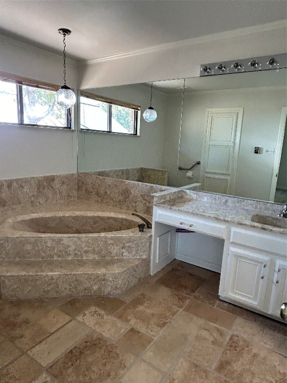 bathroom with vanity, a wealth of natural light, and a bathing tub