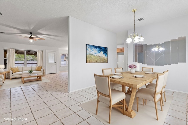 dining room with a textured ceiling, light tile patterned floors, and ceiling fan with notable chandelier