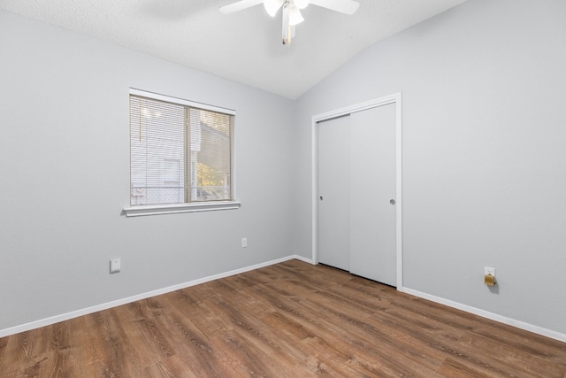 unfurnished bedroom featuring a closet, hardwood / wood-style flooring, vaulted ceiling, and ceiling fan