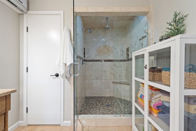 bathroom with a shower with door, vanity, a wall mounted AC, and tile patterned floors