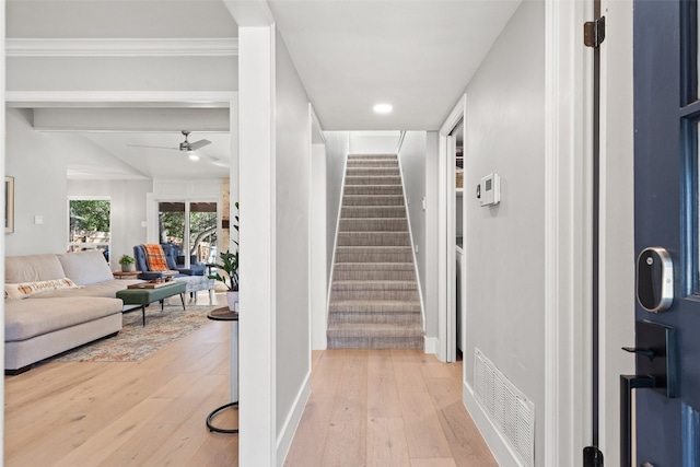 entryway with ceiling fan, hardwood / wood-style flooring, and crown molding