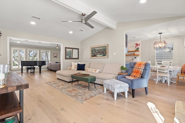 living room with light hardwood / wood-style floors, vaulted ceiling with beams, and ceiling fan with notable chandelier