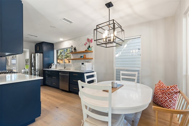 kitchen with sink, stainless steel appliances, light hardwood / wood-style flooring, and blue cabinets