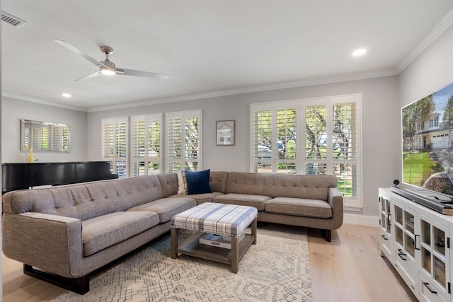 living room featuring ornamental molding, light wood-type flooring, and ceiling fan