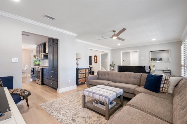 living room with light hardwood / wood-style flooring, a healthy amount of sunlight, ceiling fan, and crown molding