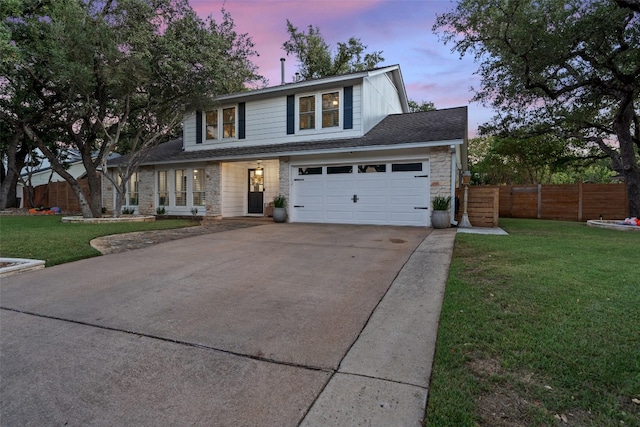 view of property featuring a garage and a lawn