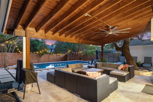 patio terrace at dusk with a fenced in pool, ceiling fan, and an outdoor hangout area