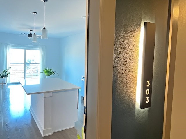 kitchen with ceiling fan, decorative light fixtures, and hardwood / wood-style floors