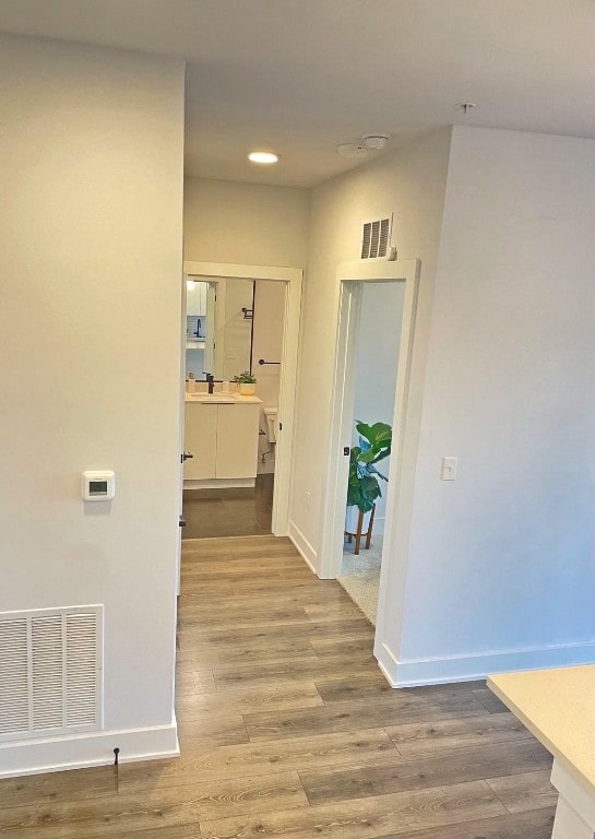 corridor featuring sink and light hardwood / wood-style flooring