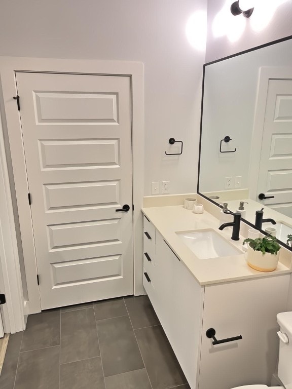 bathroom featuring vanity, toilet, and tile patterned flooring