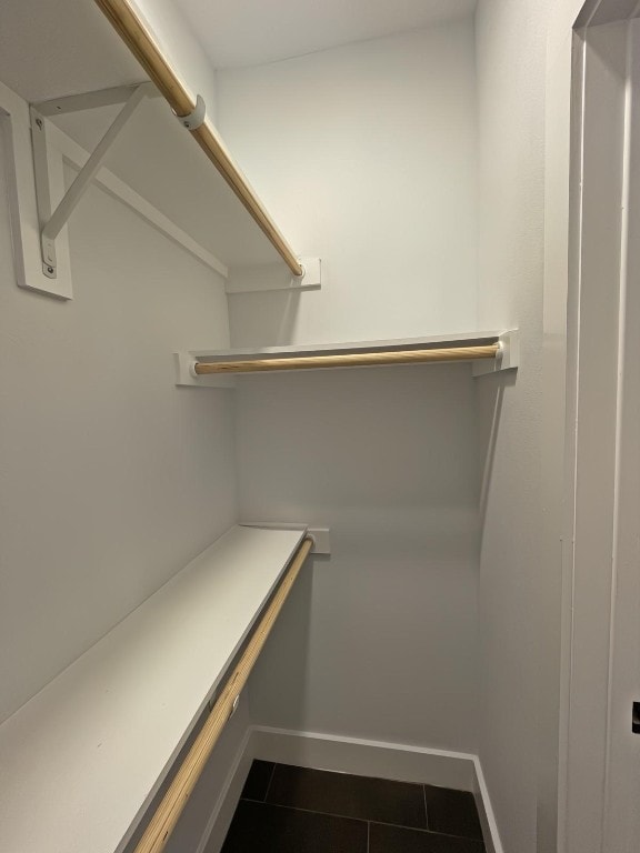 walk in closet featuring dark tile patterned flooring