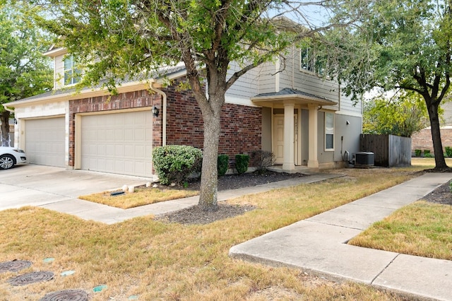 view of front of house featuring central air condition unit, a front lawn, and a garage