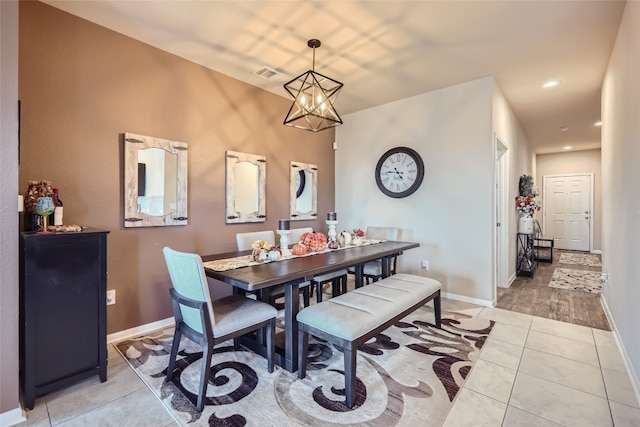 dining room featuring light tile patterned flooring and a notable chandelier