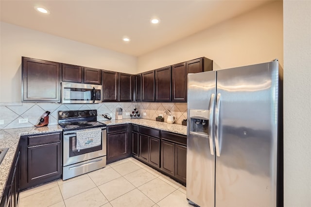 kitchen featuring dark brown cabinetry, light stone counters, and stainless steel appliances