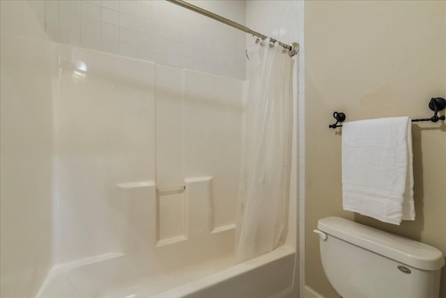 bathroom with shower / bath combination with curtain and toilet