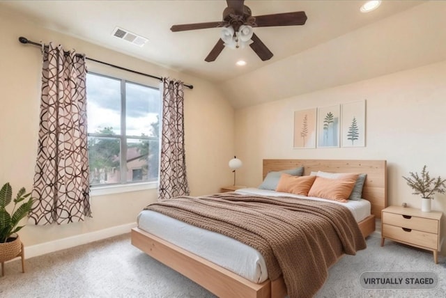 bedroom with ceiling fan, light colored carpet, and vaulted ceiling