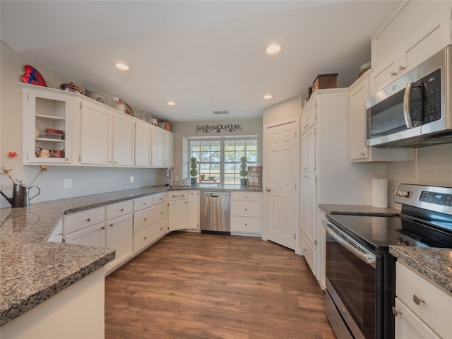 kitchen featuring stone countertops, stainless steel appliances, dark hardwood / wood-style flooring, and white cabinets