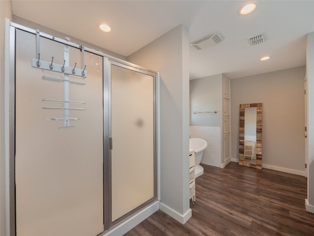 bathroom with independent shower and bath and wood-type flooring