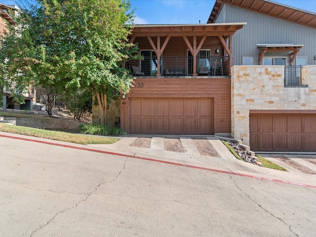 view of front of property featuring a balcony and a garage