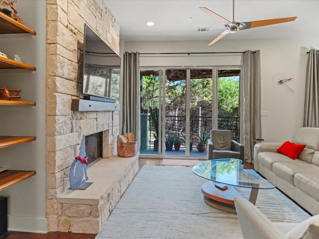 living room featuring ceiling fan, a fireplace, and hardwood / wood-style floors