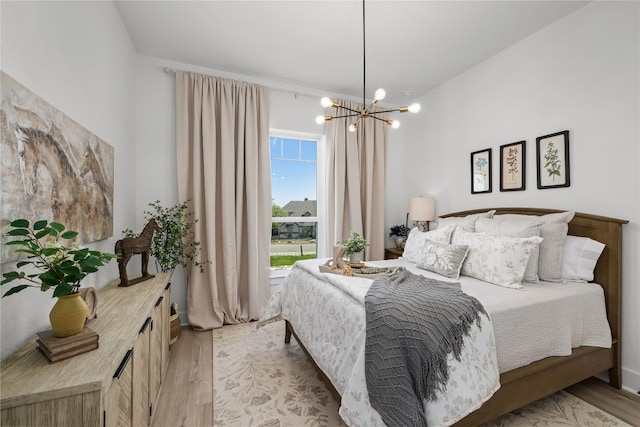 bedroom with light hardwood / wood-style floors and a chandelier