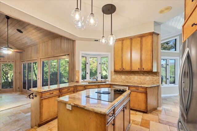 100 Silver Spur, Horseshoe Bay, TX 78657 - kitchen with stone tile floors, freestanding refrigerator, black electric stovetop, a peninsula, and high vaulted ceiling