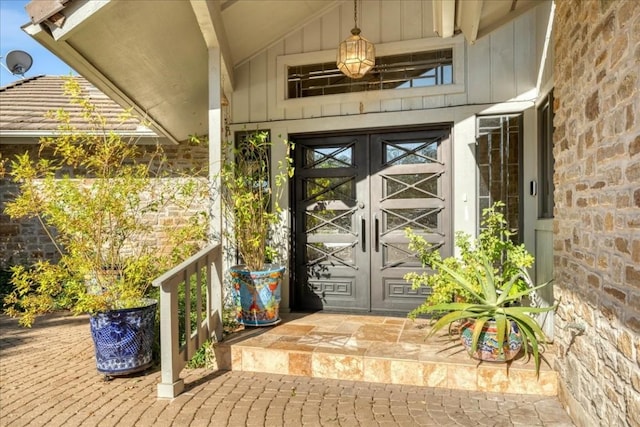 entrance to property with french doors, board and batten siding, and stone siding