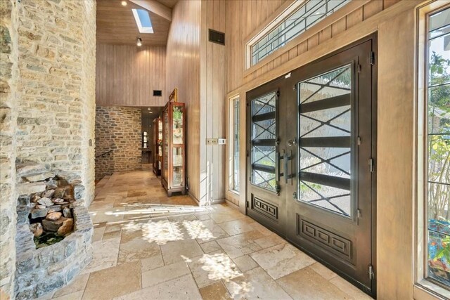 100 Silver Spur, Horseshoe Bay, TX 78657 - entryway with high vaulted ceiling, stone tile floors, healthy amount of natural light, wood ceiling, and a skylight