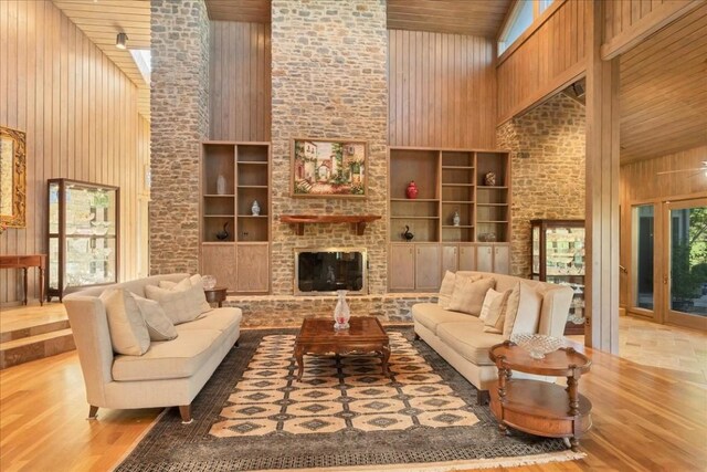 100 Silver Spur, Horseshoe Bay, TX 78657 - living area with a high ceiling, wooden walls, wood finished floors, a fireplace, and built in shelves
