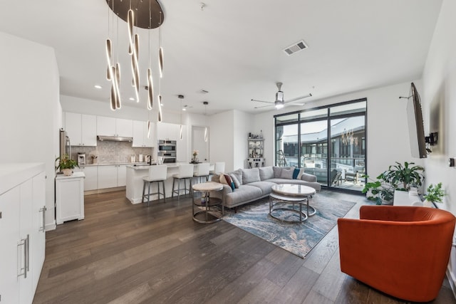 living room with dark wood-type flooring and ceiling fan