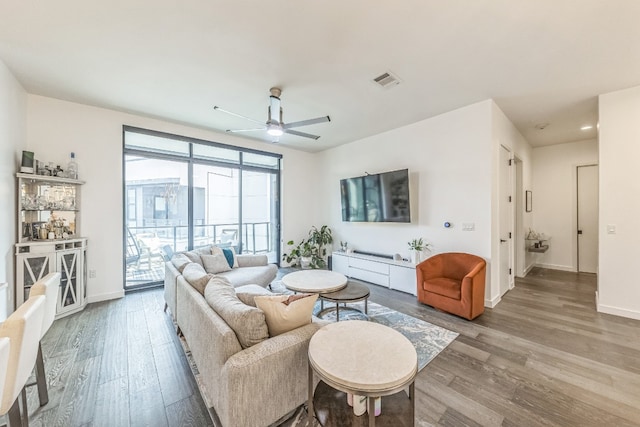 living room featuring ceiling fan and hardwood / wood-style floors