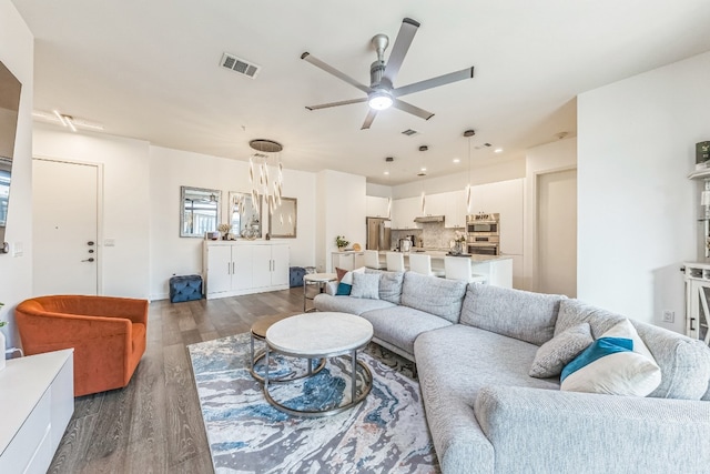 living room featuring dark wood-type flooring and ceiling fan